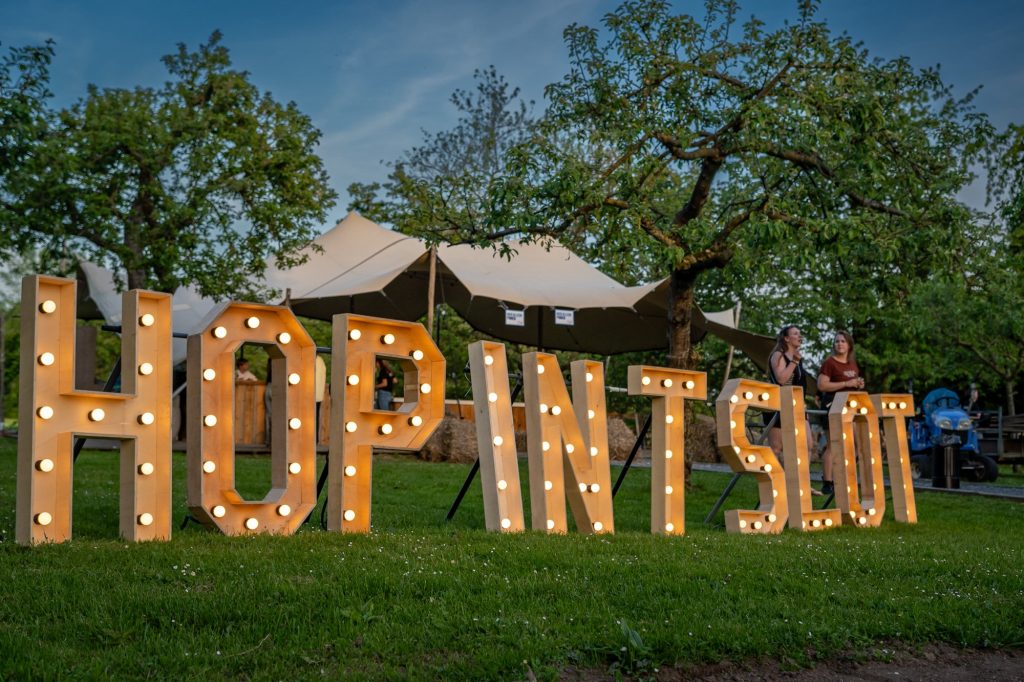 bezoekers achter de verlichte Hop in 't Slot letters tijdens bierfestival